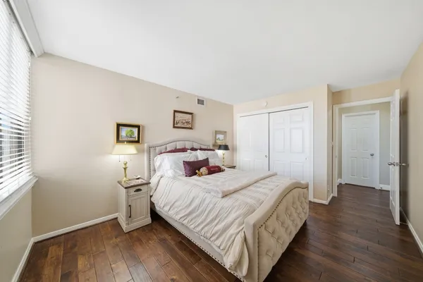 a bedroom with a bed and a wooden floor