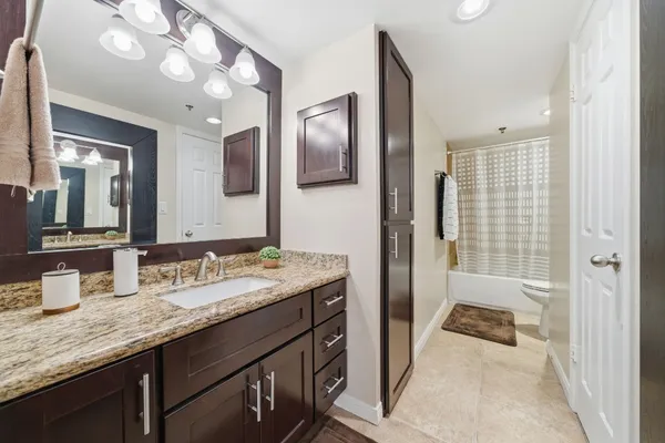 a en suite bathroom with a granite countertop sink mirror and a