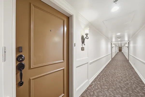 a view of a hallway with wooden floor and staircase