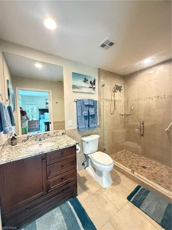 6140 Standing Oaks Lane Naples, FL 34119 - Photo 11 of 13 a bathroom with a granite countertop sink toilet mirror and bathtub