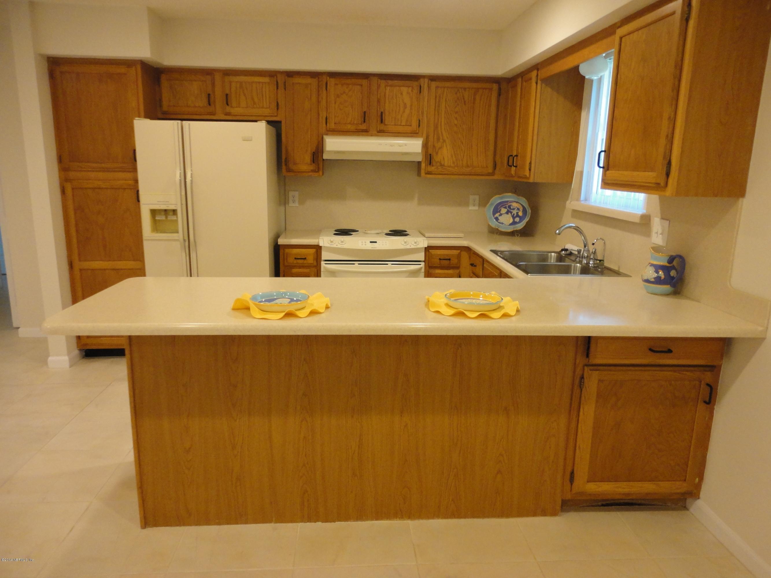 323 Gentian Road St. Augustine, FL 32086 - Photo 8 of 24 a kitchen with kitchen island a sink a stove and refrigerator