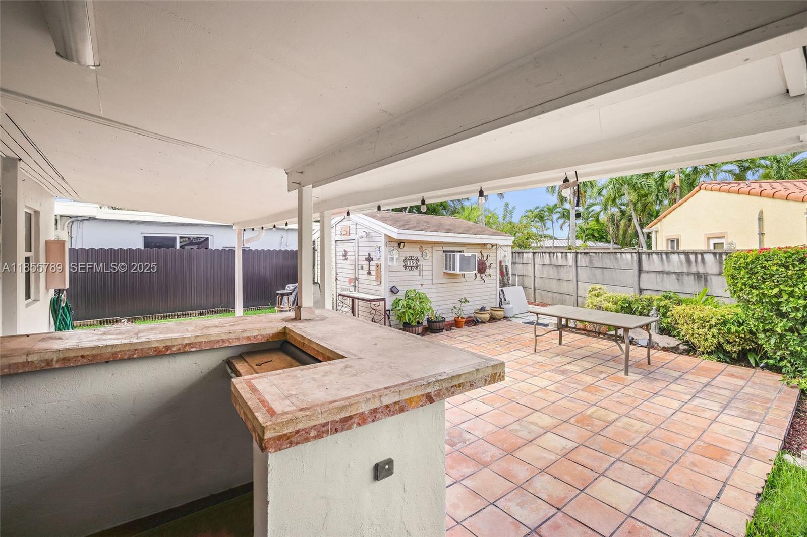 7550 Southwest 28th Street Road Miami, FL 33155 - Photo 19 of 27 a view of a patio with a table and chairs next to a yard