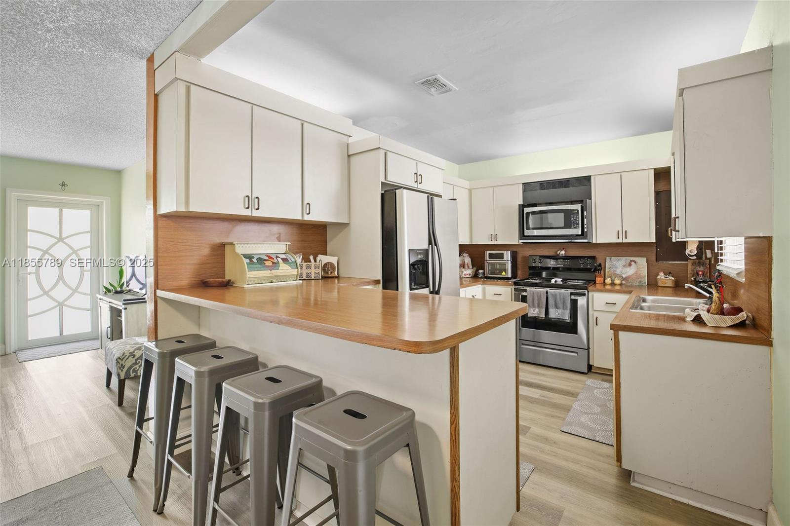 7550 Southwest 28th Street Road Miami, FL 33155 - Photo 6 of 27 a kitchen with granite countertop a sink stove and refrigerator