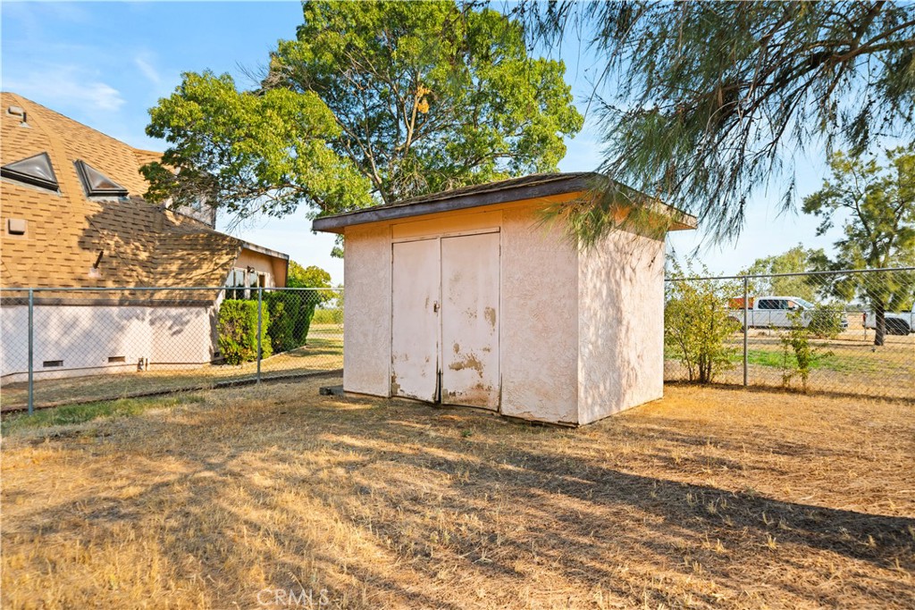 4345 Hall Road Corning, CA 96021 - Photo 34 of 52 a backyard of a house with large trees and a barn