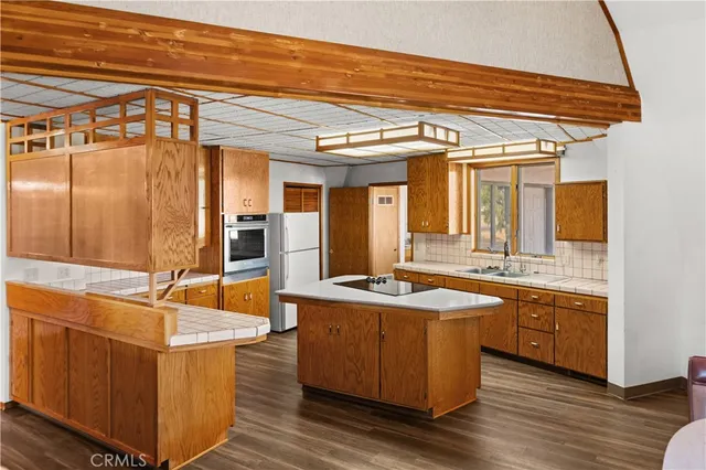 a view of a kitchen with stainless steel appliances granite countertop a sink and dishwasher a stove with wooden floor
