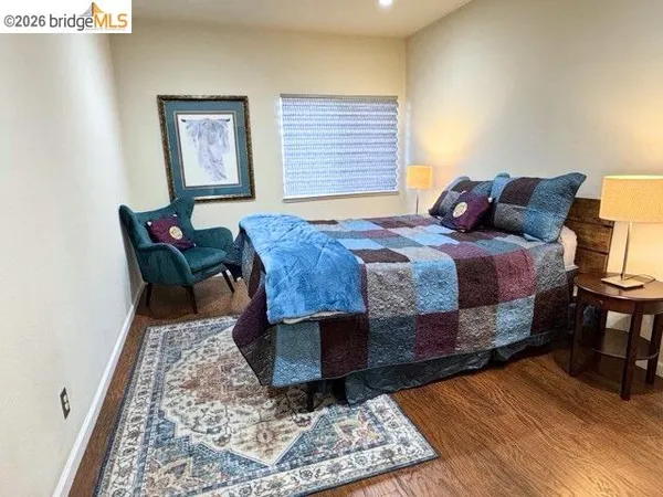 a bedroom with a bed a rug and wooden floor