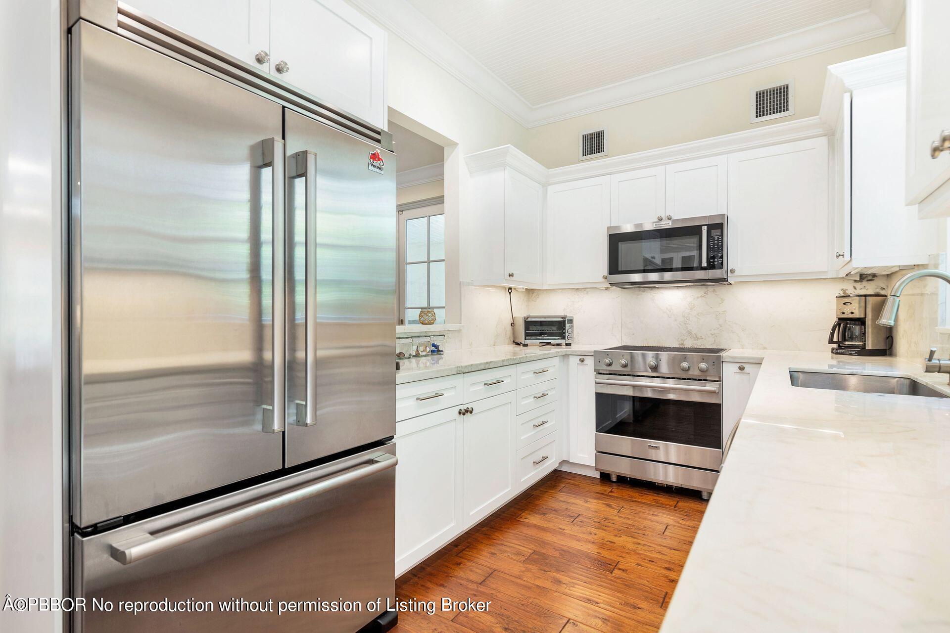 135 Root Trail, Unit A Palm Beach, FL 33480 - Photo 12 of 25 a kitchen with stainless steel appliances a refrigerator sink and stove