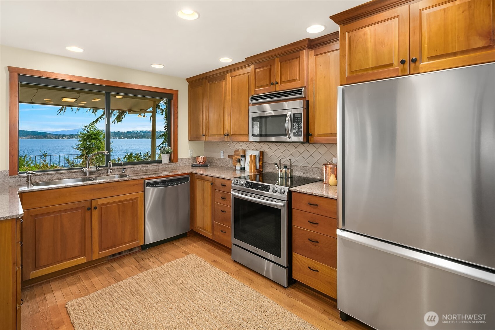 6555 Northeast Windermere Road Seattle, WA 98105 - Photo 13 of 38 a kitchen with stainless steel appliances granite countertop a refrigerator a sink dishwasher a stove with wooden cabinets and floors