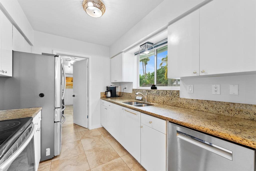 1257 Northwest 5th Street Boca Raton, FL 33486 - Photo 16 of 44 a kitchen with a sink stove and cabinets