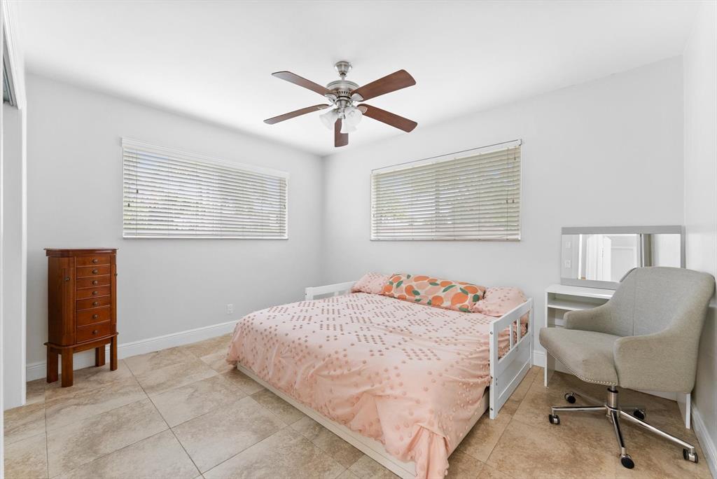 1257 Northwest 5th Street Boca Raton, FL 33486 - Photo 19 of 44 a bedroom with a bed and a chair