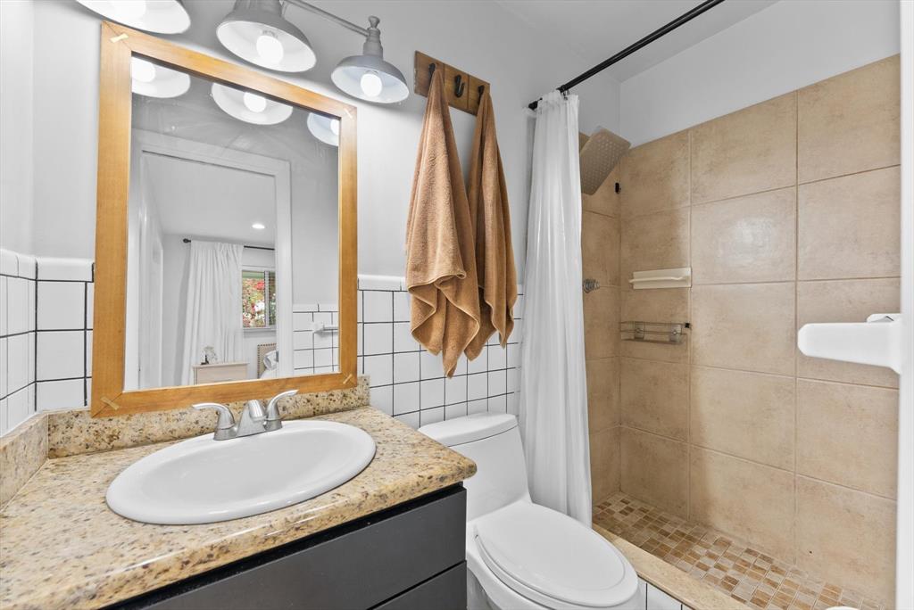 1257 Northwest 5th Street Boca Raton, FL 33486 - Photo 28 of 44 a bathroom with a granite countertop sink toilet a mirror and shower