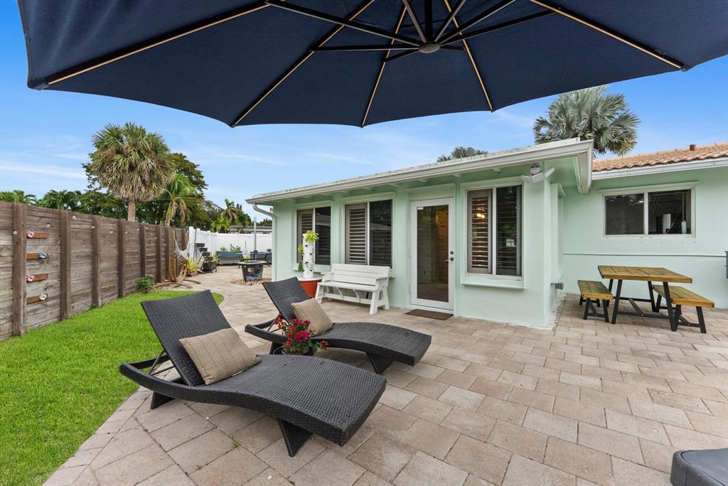1257 Northwest 5th Street Boca Raton, FL 33486 - Photo 31 of 44 a patio with tables and chairs under an umbrella
