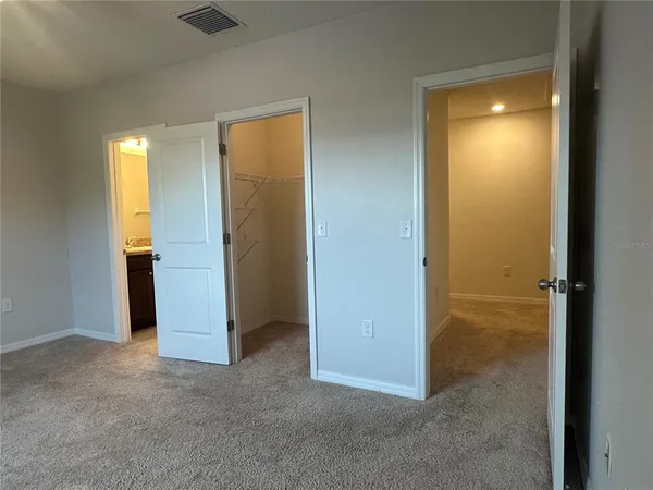 an empty room with closet and a bathroom