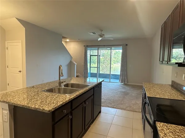 a kitchen with a granite countertop sink and cabinets