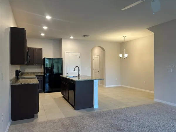 a view of kitchen with kitchen island stainless steel appliances refrigerator sink and stove