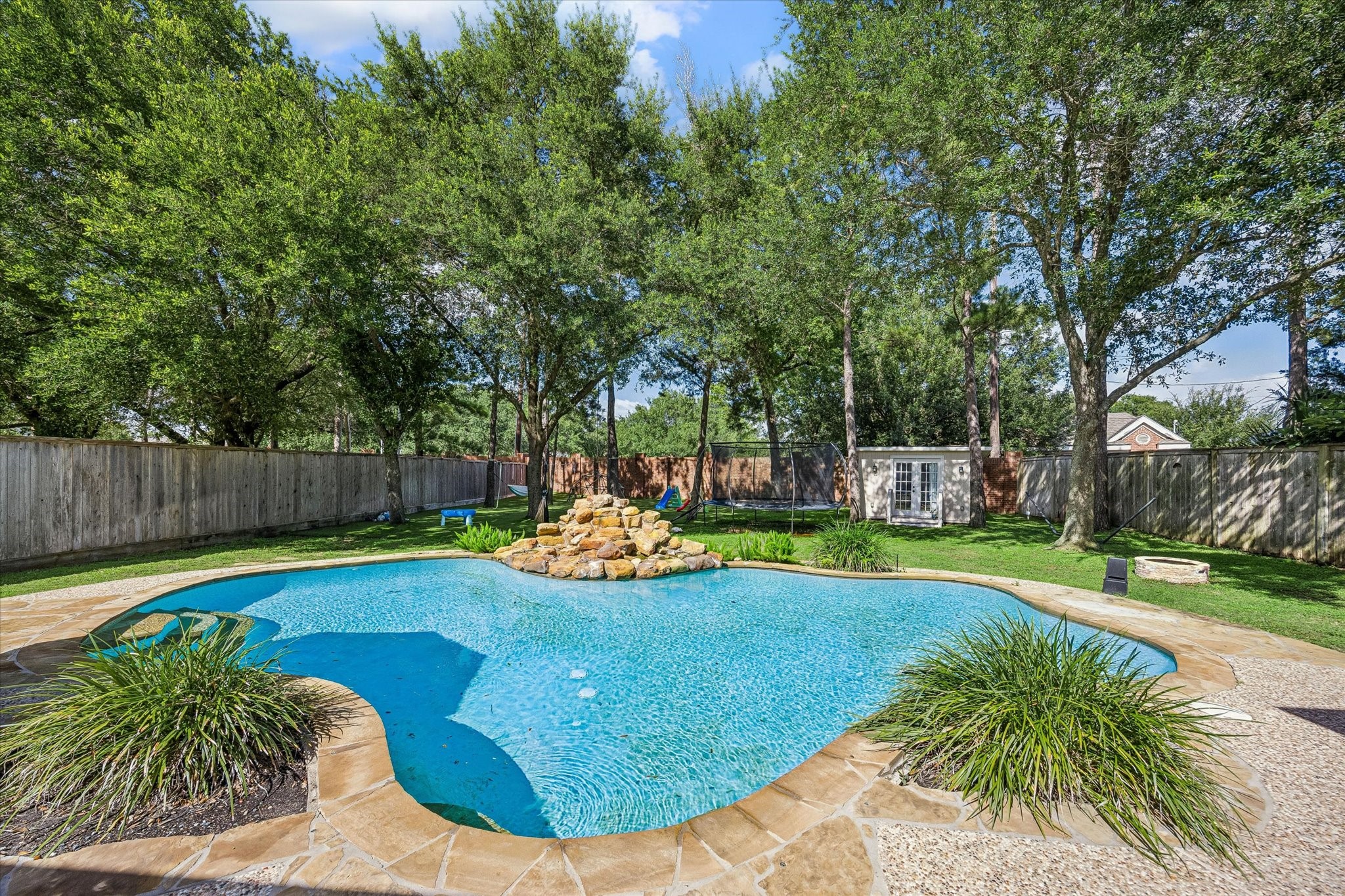 3047 Bonnebridge Way Boulevard Houston, TX 77082 - Photo 25 of 50 Exquisite pool overlooks an expansive backyard with a beautifully maintained lawn and the shade of mature trees, creating a peaceful outdoor setting. This private retreat offers the perfect place to relax, unwind, and enjoy the beauty of the surrounding landscape.