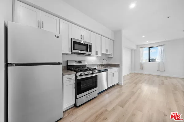 a kitchen with stainless steel appliances a refrigerator stove and microwave