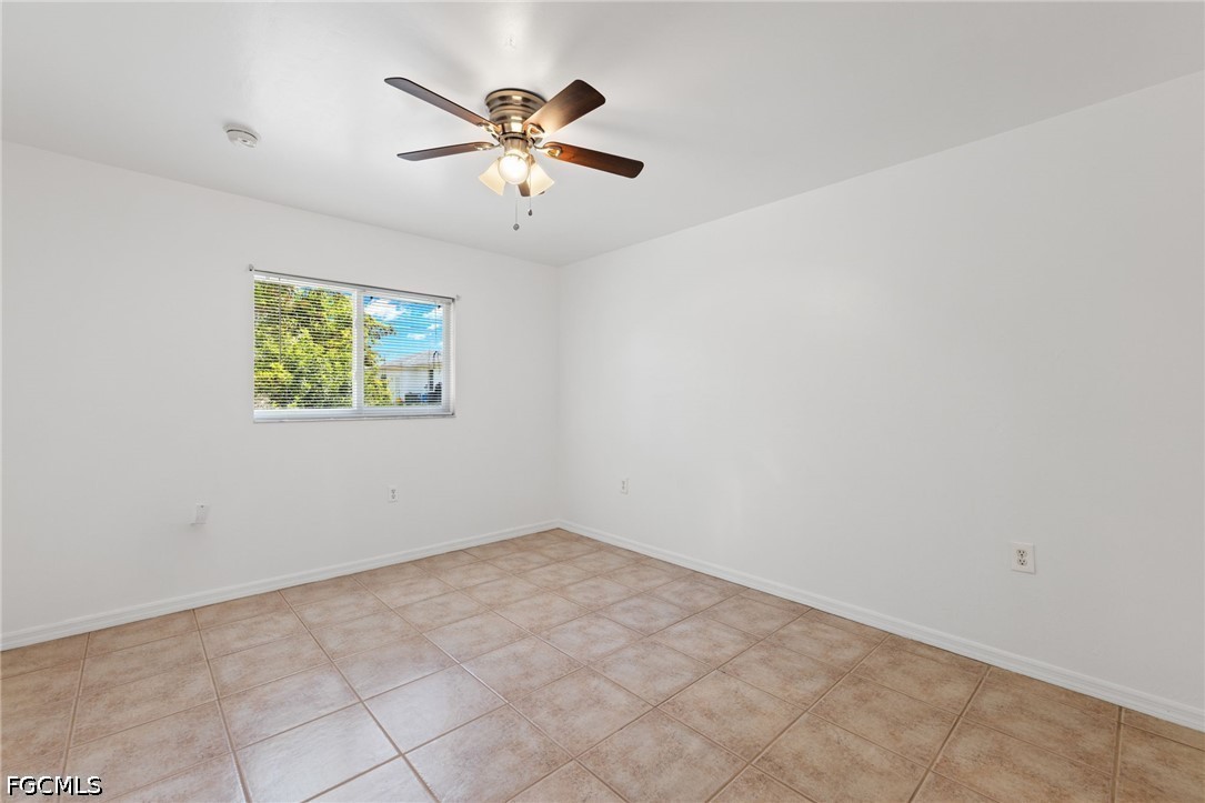 221 Meadow Road Lehigh Acres, FL 33973 - Photo 10 of 13 an empty room with windows and fan