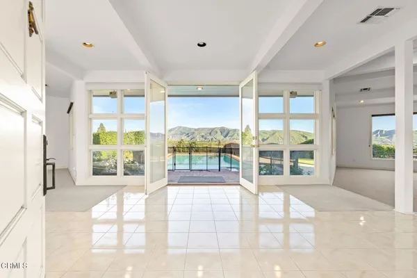 a view of an empty room with wooden floor and a fireplace