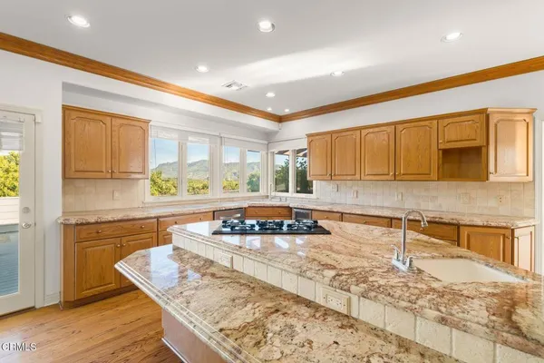 an empty room with wooden floor fireplace and windows