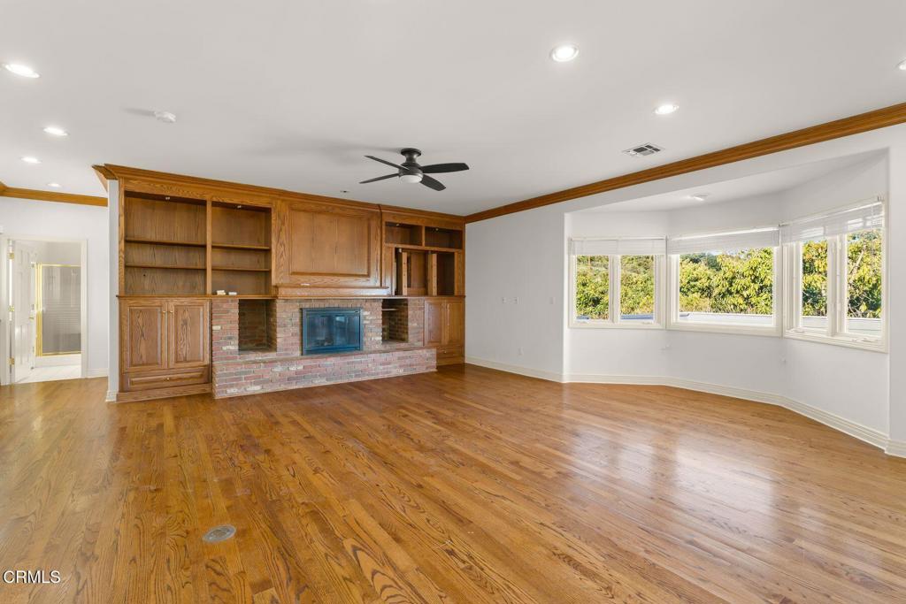 13922 Foothill Road Santa Paula, CA 93060 - Photo 8 of 36 an empty room with wooden floor fireplace and windows