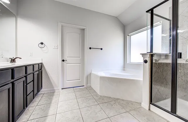 a bathroom with a tub sink and mirror