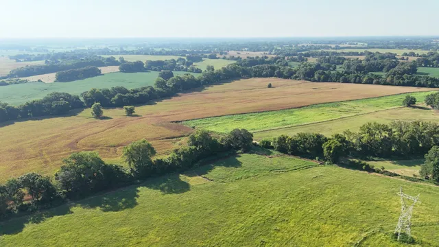 an aerial view of a houses with yard and lake view