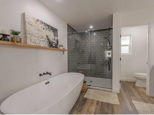 a bathroom with a toilet a double vanity sink and a mirror