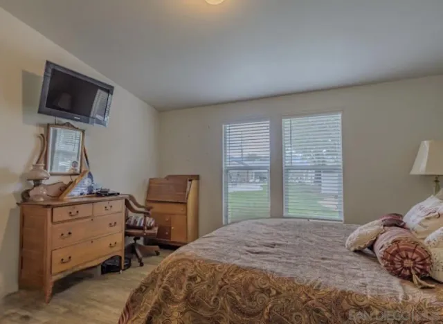 a backyard of a house with table and chairs under an umbrella