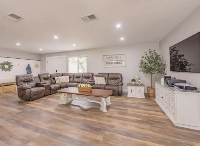 a living room with furniture a flat screen tv and a potted plant