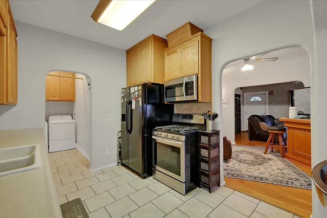 a kitchen with stainless steel appliances granite countertop a refrigerator and a stove top oven