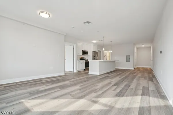 a view of an empty room with wooden floor