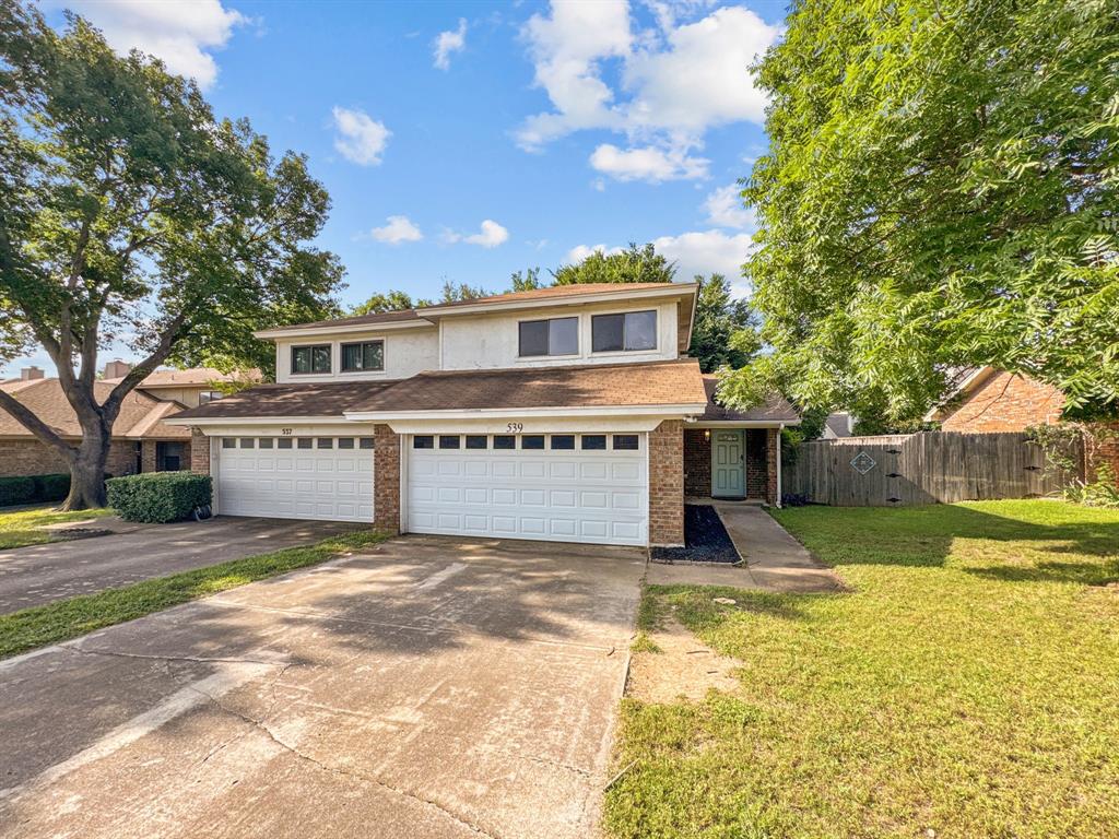 a view of a house with a patio and a yard