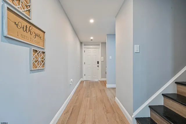 a view of a hallway with wooden floor and staircase