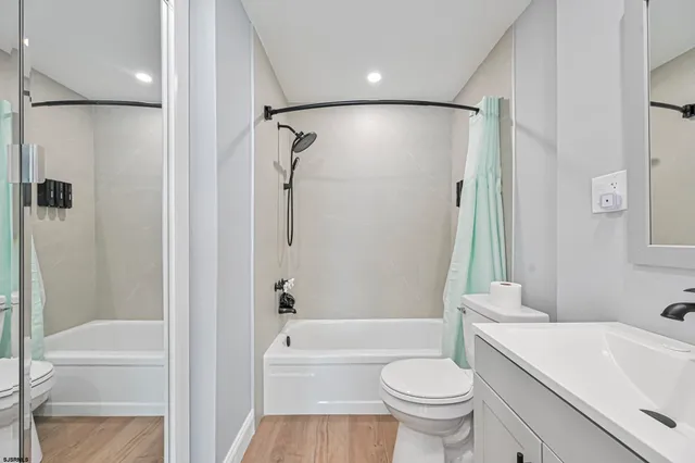 a bathroom with a bathtub shower sink vanity and toilet