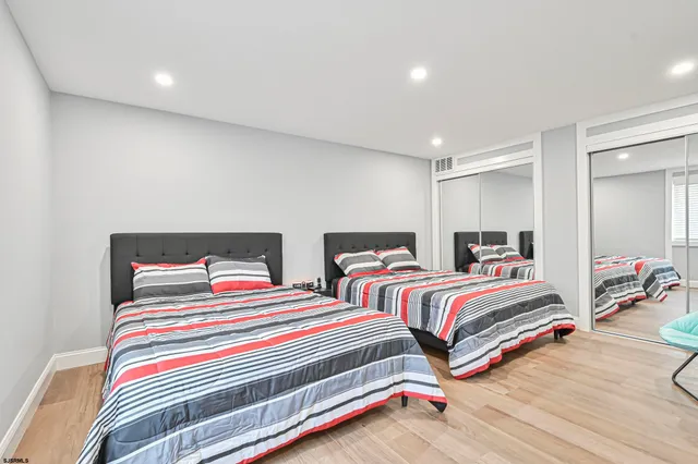 a bedroom with two beds and a dresser