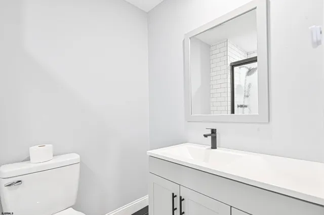 a bathroom with a sink a toilet and mirror