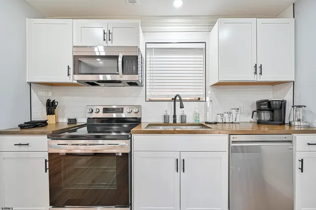 a kitchen with cabinets stainless steel appliances and a sink