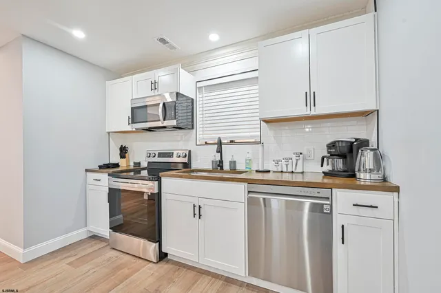 a kitchen with stainless steel appliances granite countertop a sink and cabinets