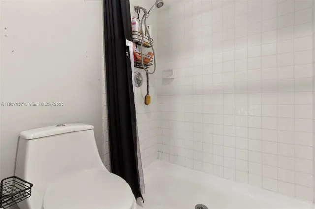 a bathroom with a toilet and a shower