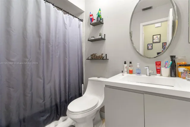 a bathroom with a sink vanity mirror and toilet