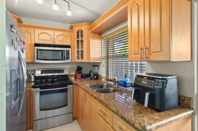 a kitchen with granite countertop a stove top oven microwave and cabinets