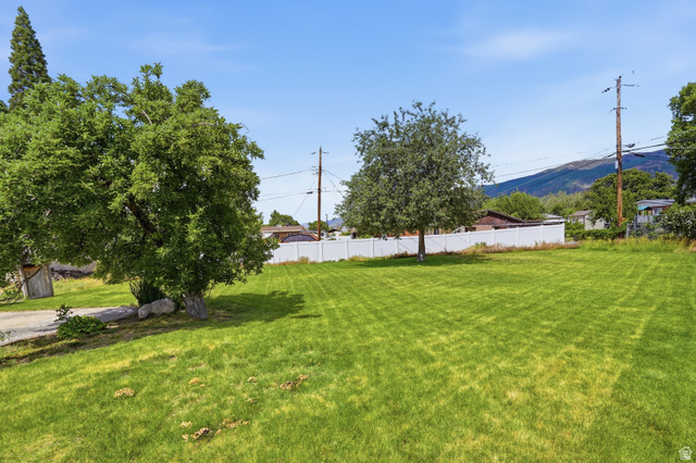 378 West 200 South Bountiful, UT 84010 - Photo 30 of 32 Expansive green lawn with mature trees and a white privacy fence