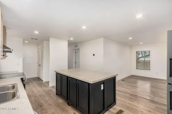 a kitchen with a wooden floor and large cabinets