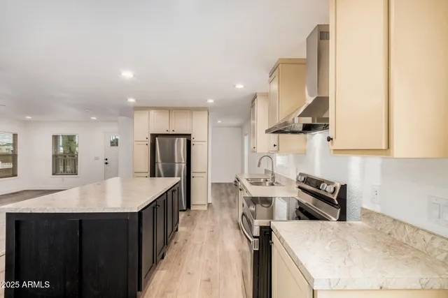 a kitchen with stainless steel appliances granite countertop a sink a stove and a refrigerator