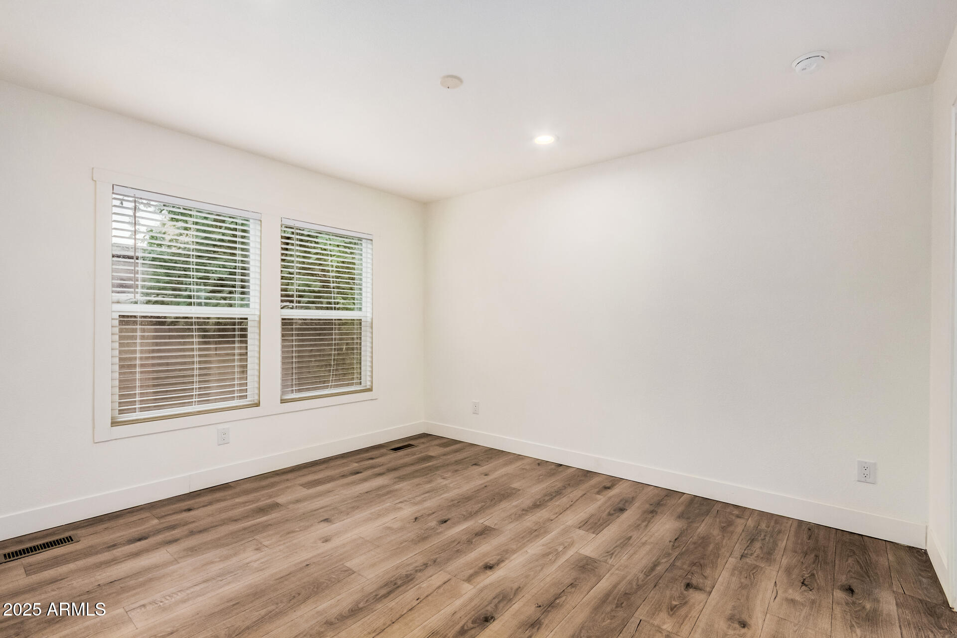 11441 East 4th Avenue Apache Junction, AZ 85120 - Photo 14 of 30 an empty room with wooden floor and windows