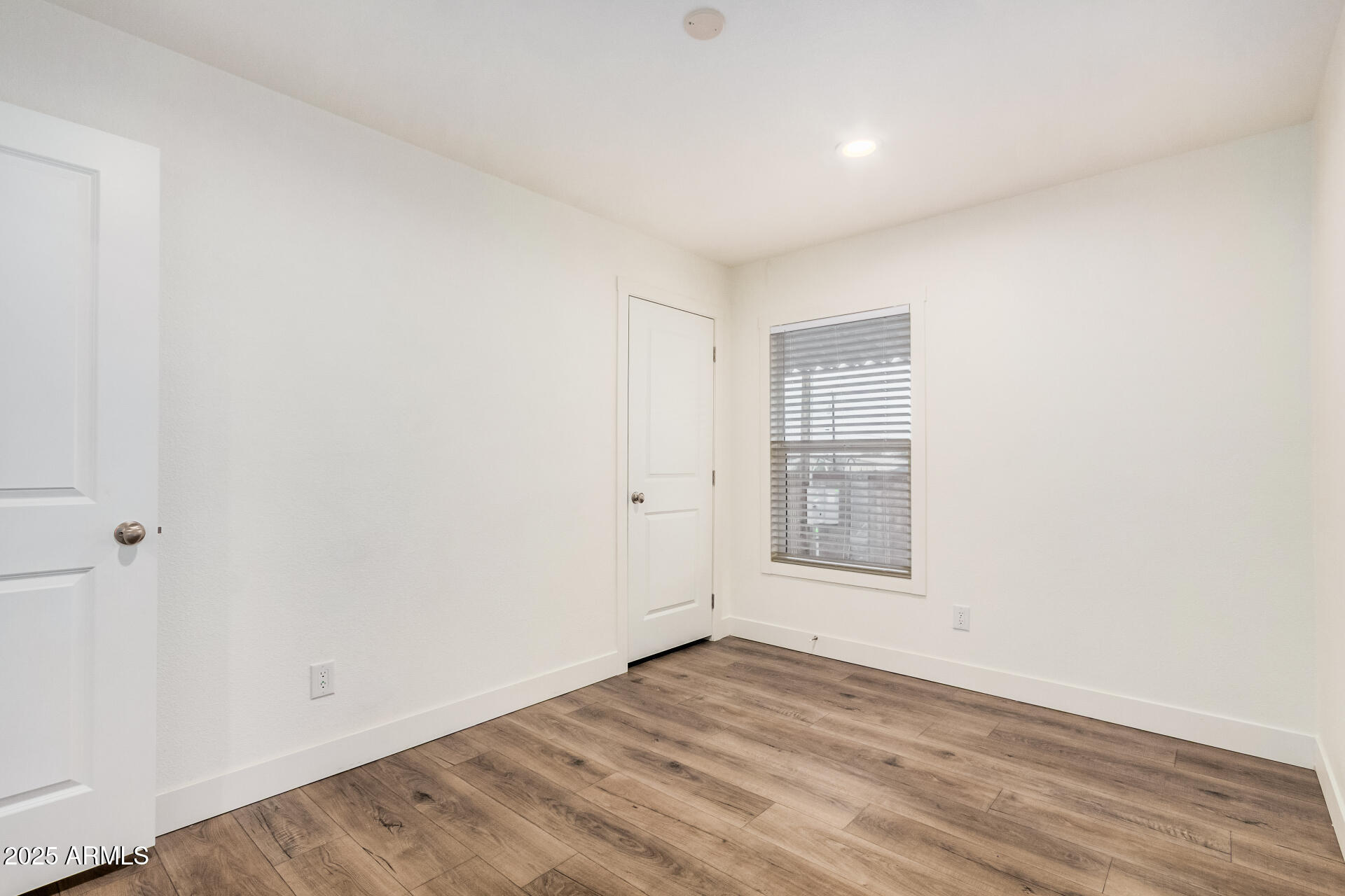 11441 East 4th Avenue Apache Junction, AZ 85120 - Photo 22 of 30 an empty room with wooden floor and windows