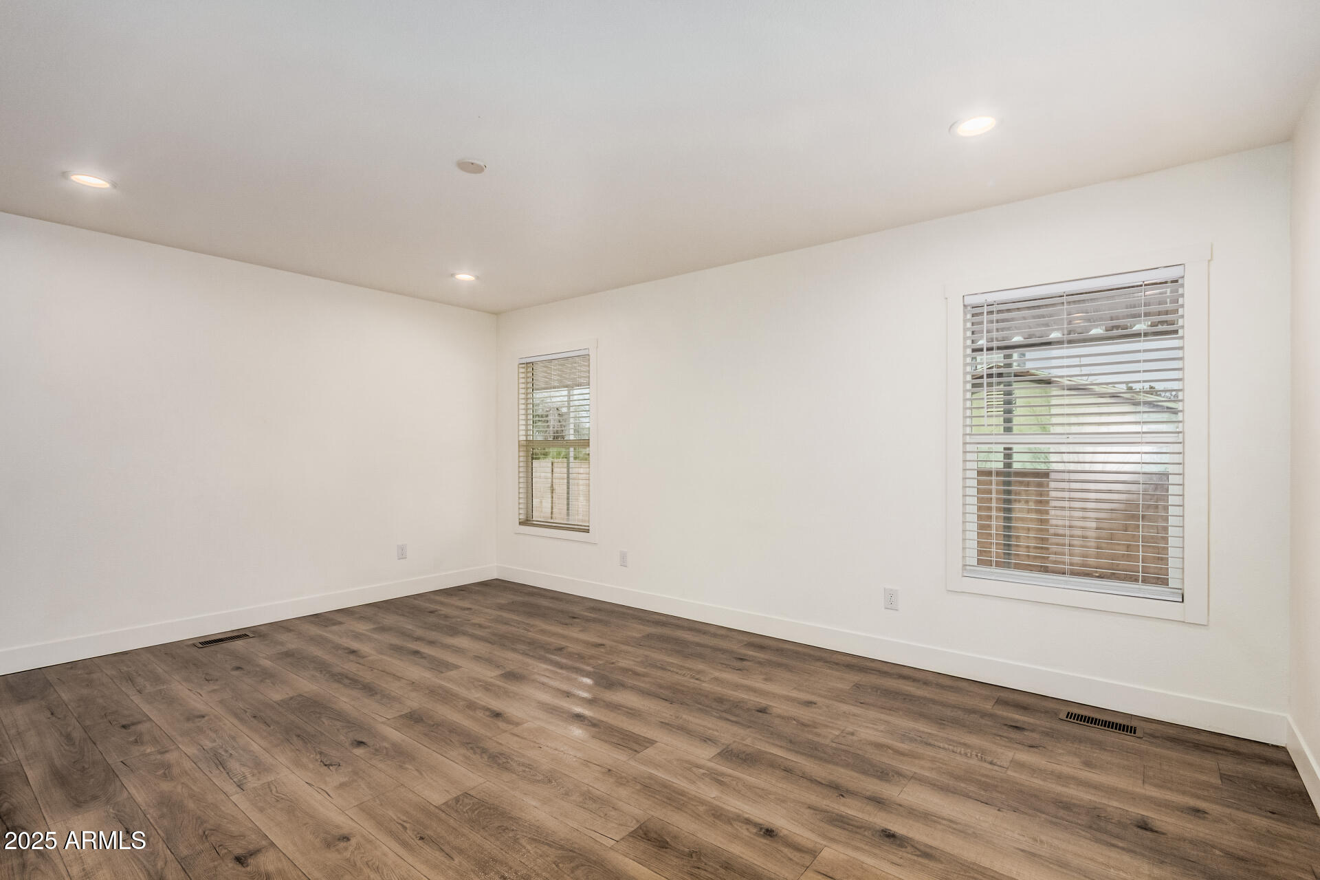 11441 East 4th Avenue Apache Junction, AZ 85120 - Photo 3 of 30 an empty room with wooden floor and windows