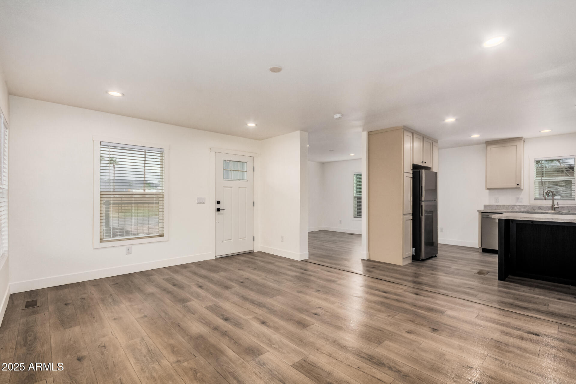11441 East 4th Avenue Apache Junction, AZ 85120 - Photo 5 of 30 a view of an empty room with wooden floor and a kitchen