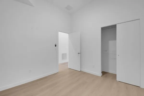 an empty room with ceiling fan and window